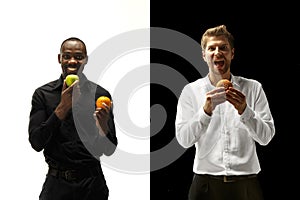 Men eating a hamburger and fruits on a black and white background