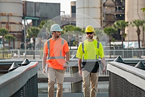 Men engineer workers, factory operators, mechanical engineering team production. Workers in helmet walk on industry zone