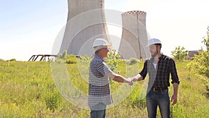 Men engineers shaking hands at construction site.