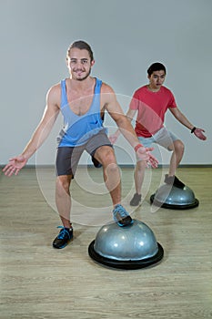 Men exercising on bosuball
