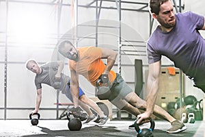 Men exercising with kettlebells in crossfit gym