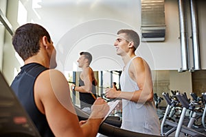 Men exercising on treadmill in gym