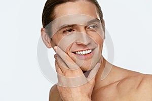 Men Face Care. Man Touching Smooth Skin After Shaving