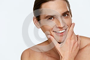 Men Face Care. Man Touching Smooth Skin After Shaving