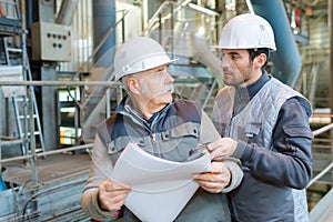 men in factory looking at paperwork