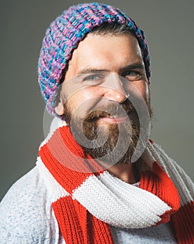 Men fashion. Closeup portrait of smiling bearded man in hat and scarf. Winter knitwear. Fashionable handsome man with