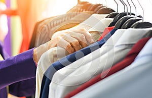 Men fashion clothes - Hanging clothes suit colorful or closet rack different coloured man suits in a closet on hangers in a store
