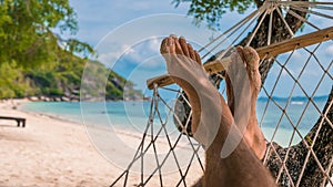 Men feet in Hammock, relaxing on the beach in Haad Rin, Ko Phangan