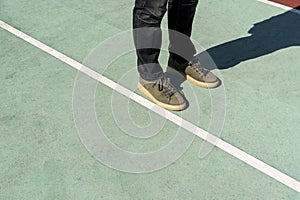 Men feet stand on the rubberized sports ground