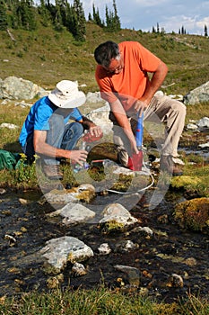 Men Filtering Water from Mountain Stream 4