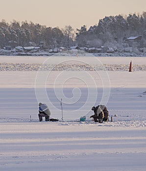 men fishermen are engaged in fishing in winter on the ice