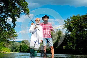 Men fishing. Fishing anglers in river water. Old and young fisherman.