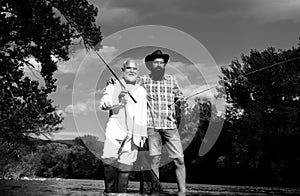 Men fishing. Fishing anglers in river water. Old and young fisherman.