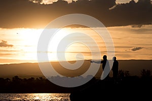 Men fishing at the lake at sunset photo