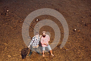 Men fishing in river during summer day. Fishing became a popular recreational activity. Fisherman fishing with spinning