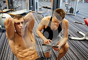 Men flexing abdominal muscles in gym