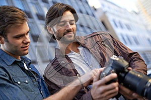 Men, friends and photographer with camera in outdoor, capture and city for creativity in London. Collaboration