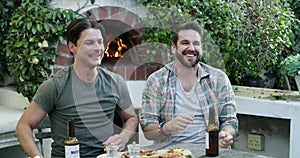 Men, friends and pizza with watching tv, celebration or beer with fire, conversation or relax in home backyard. People
