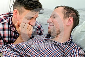 Men gay lie down together and flirt each other.