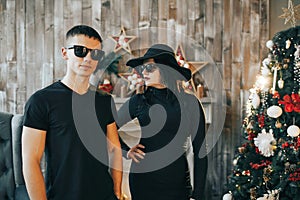 Men and a girl standing in front of a fireplace near Christmas tree