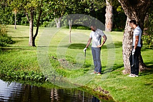 Men, grass and ball on golf course for fitness with greenery, lawn and pro. Male people, sport equipment and friends