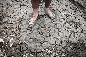 Men on ground cracked dry due to drought.