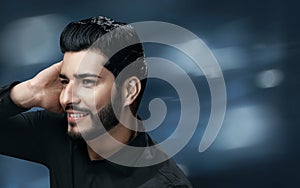 Men Hair Care. Handsome Man With Beard Touching Healthy Hair