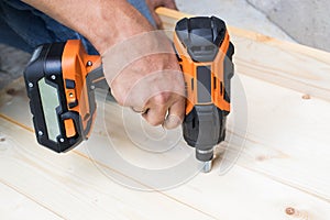 Men Hand Drilling Wooden Board With Battery Driller / Impact Wrench.