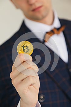 Men hand hold or giving golden bitcoin on the white background