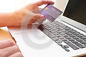 Men hand holding credit card and type payment information on keyboard for order online shopping. Internet technology and Digital