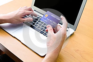 Men hand holding credit card and type payment information on keyboard for order online shopping. Internet technology and Digital