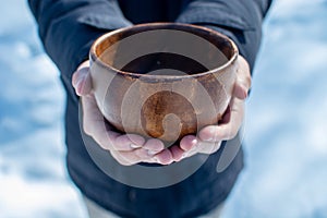 Men hand holding empty wooden bowl