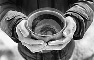Men hand holding empty wooden bowl. Black and white.