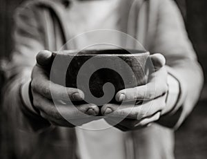 Men hand holding empty wooden bowl. Black and white