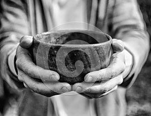 Men hand holding empty wooden bowl. Black and white