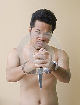 Men in handcuffs holding knife in hand