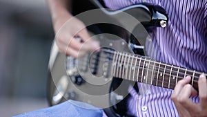 Men hands guitarist playing guitar outdoor. close-up