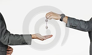 Men hands handing over house keys, apartments, cars on an isolated