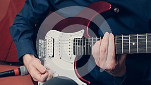 Men hands play the red electric guitar photo