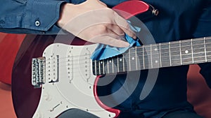 Men hands take care of electric guitar wiping tool from dust photo