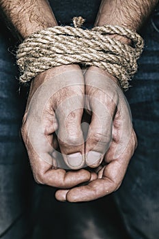 Men hands are tied with a rope. The concept of imprisonment in modern society photo
