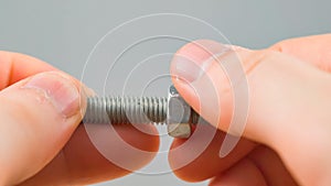 Men hands tighten nut on the screw closeup