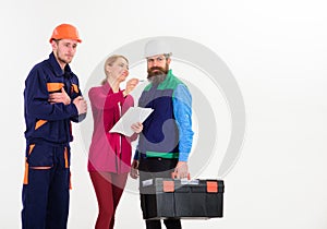 Men in hard hats and uniform and female supervisor