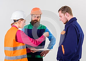 Men in hard hats, uniform and woman.