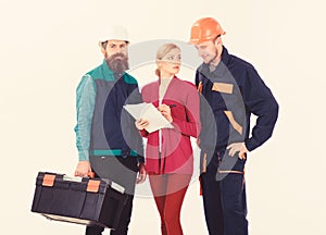 Men in hard hats and uniform and woman in suit