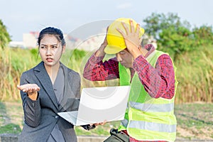 Men in hard hats and uniform with young woman. Team of architects, engineers discussing work. A women hold laptop