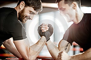 Men having arm wrestling in the gym