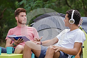 men having conversation outside tent