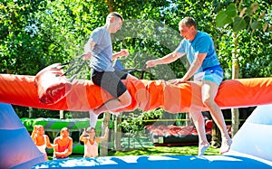 Men having pillow fight between each other in outdoor amusement park