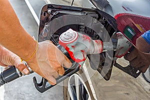 Men hold Fuel nozzle to add fuel in car